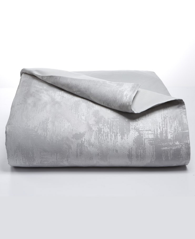 A folded grey comforter with a subtle texture
