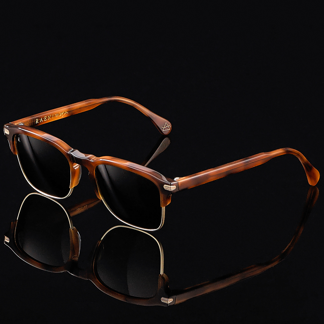 Luxury studio shot of Raen sunglasses on a reflective black surface