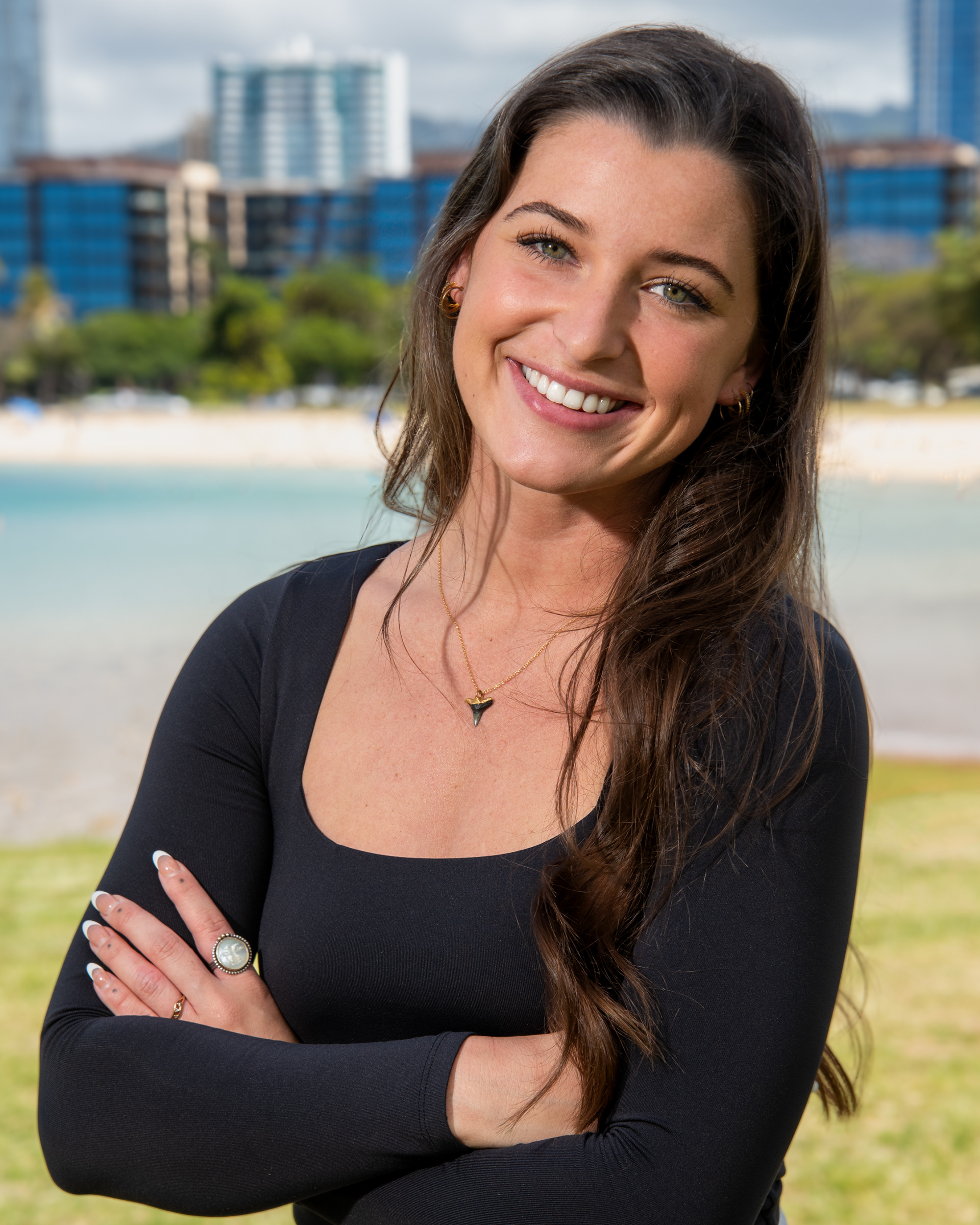 Outdoor portrait of a smiling woman with a beach and city in the background