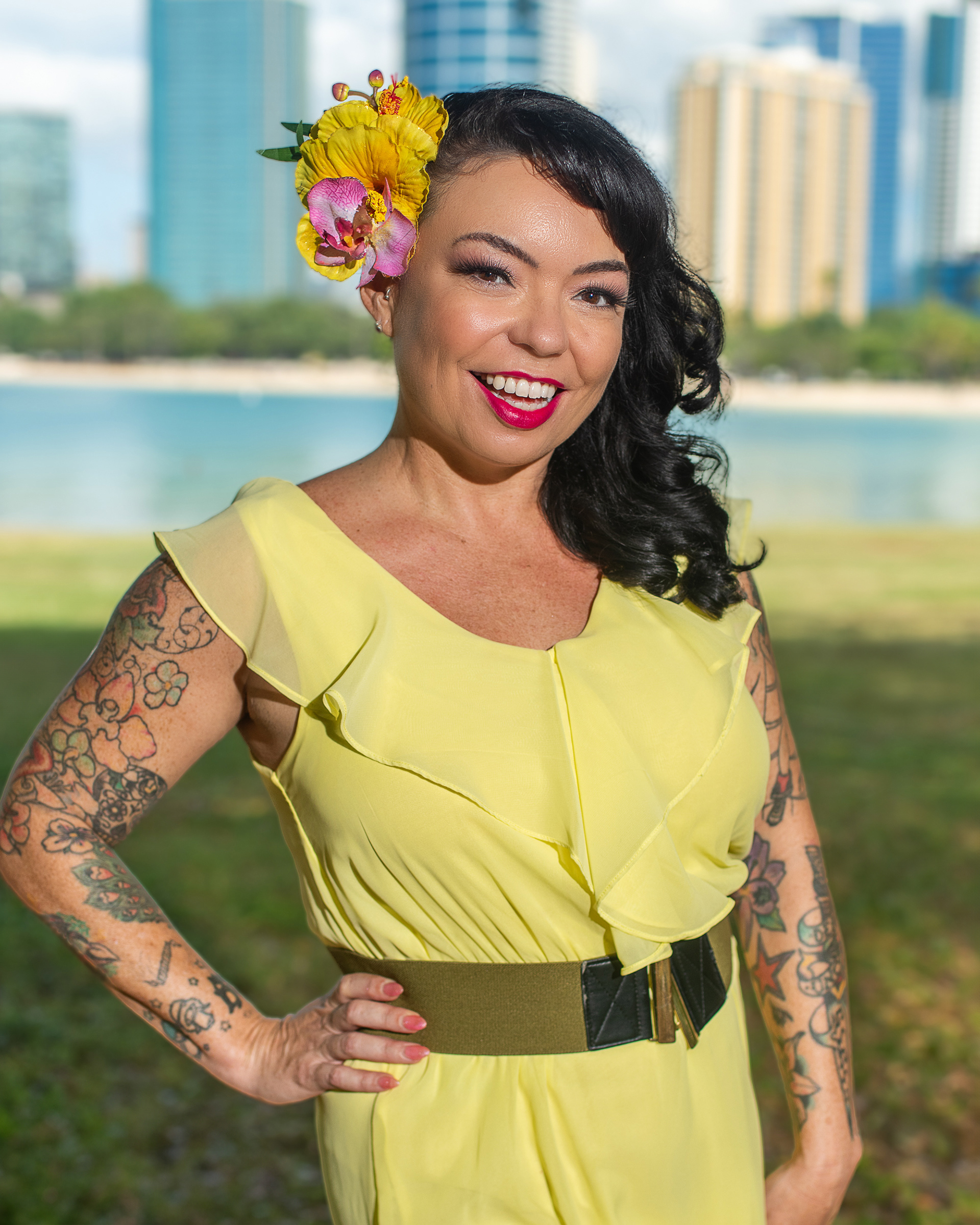 Vibrant outdoor portrait of a woman in a yellow dress with a flower in her hair